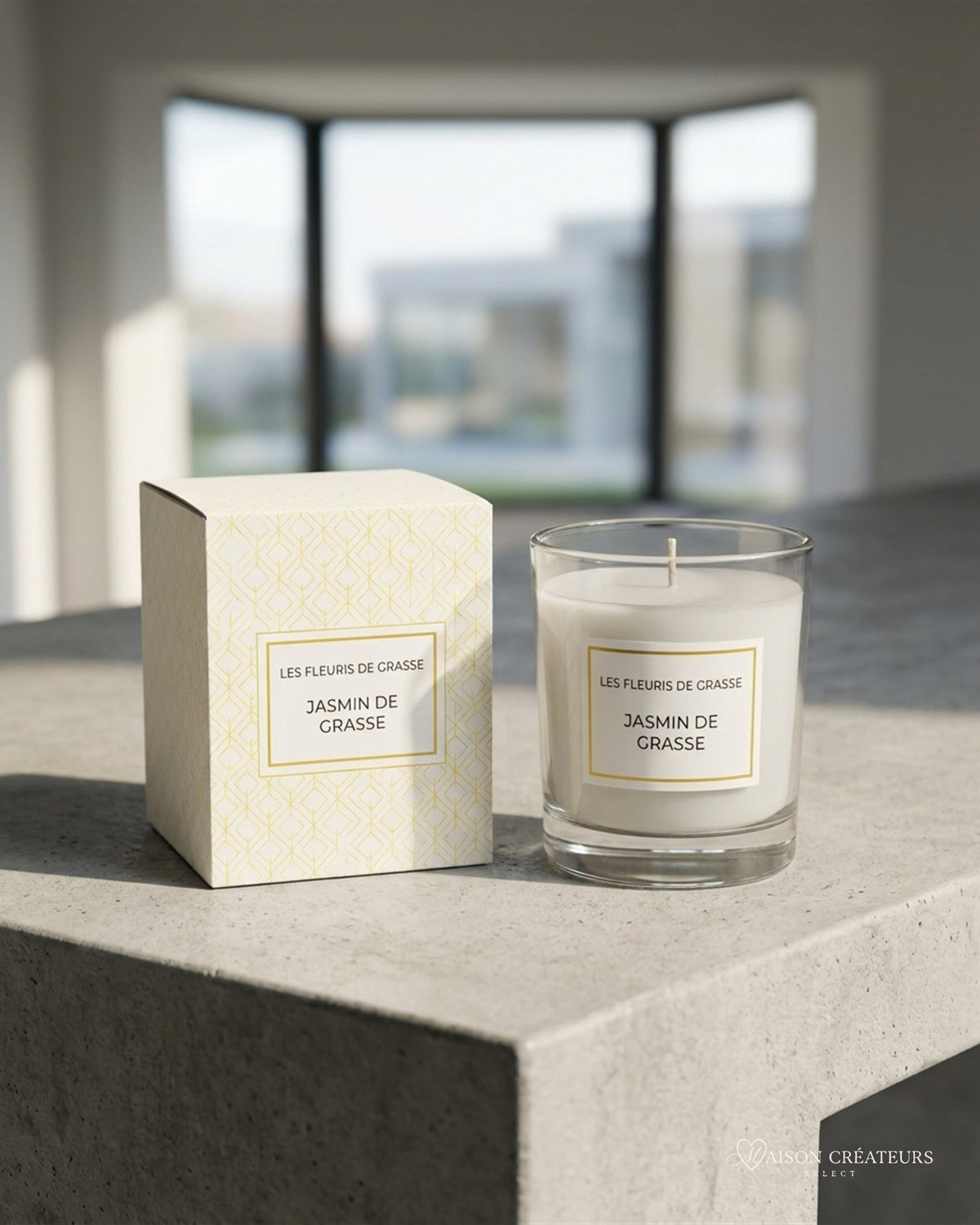 Bougie parfumée 130 g Jasmin de Grasse posée sur du béton dans un atrium lumineux