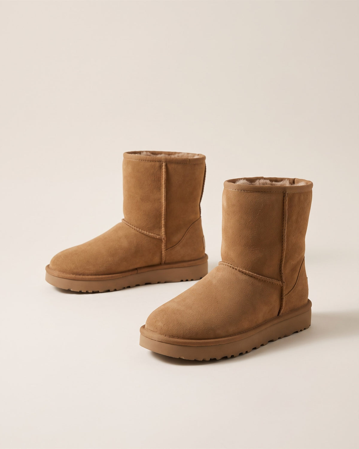 Bottes fourrées camel en suédine, vue de face sur fond pierre