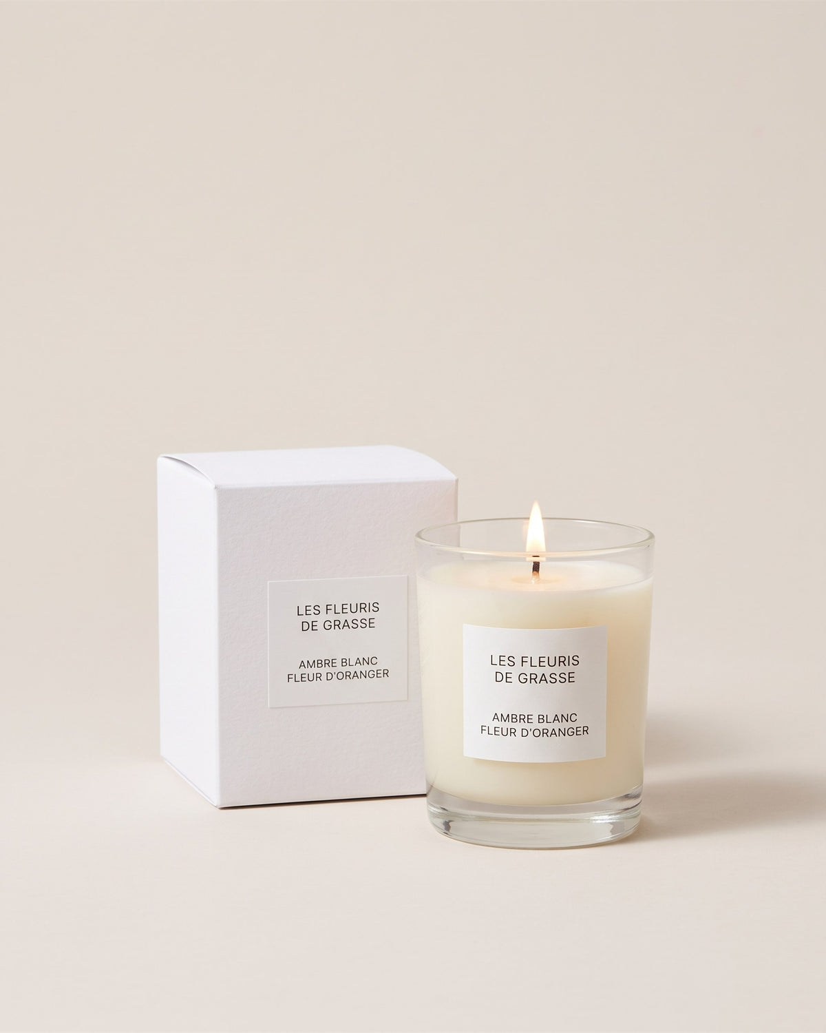 Bougie parfumée 130 g Ambre Blanc Fleur d Oranger, verre et coffret, vue de face sur fond pierre