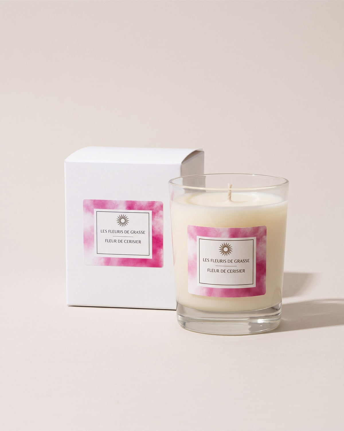 Bougie parfumée 130 g Cerisiers en fleurs, verre et coffret rose, vue de face sur fond pierre
