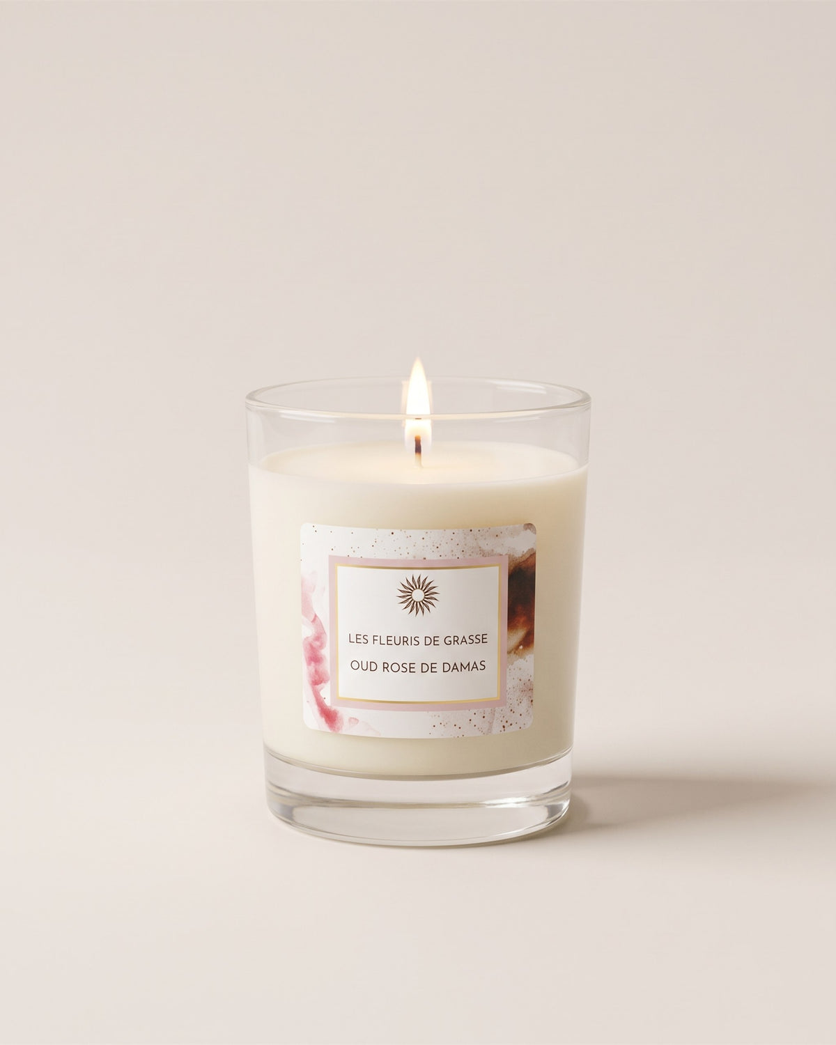 Bougie parfumée 130 g Oud Rose de Damas dans son verre, vue de face sur fond pierre