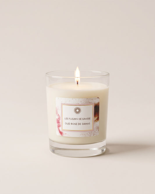 Bougie parfumée 130 g Oud Rose de Damas dans son verre, vue de face sur fond pierre