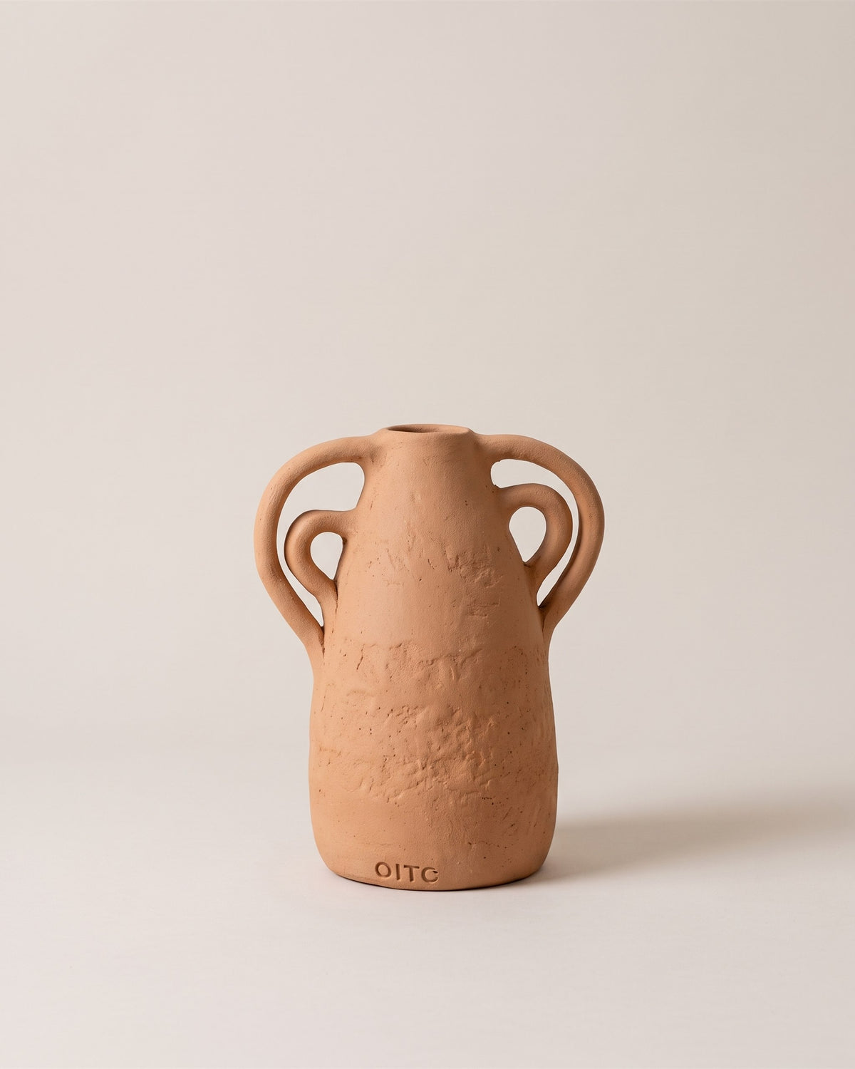 Vase amphore artisanal en céramique terracotta fait main au Portugal, vue de face sur fond pierre