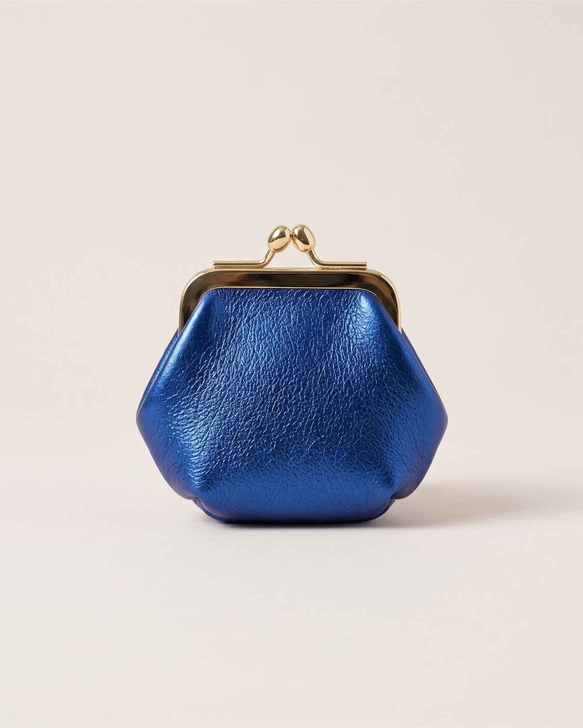 Le porte-monnaie rétro en cuir métallisé bleu roi à fermoir doré à boules, vue de face sur fond pierre