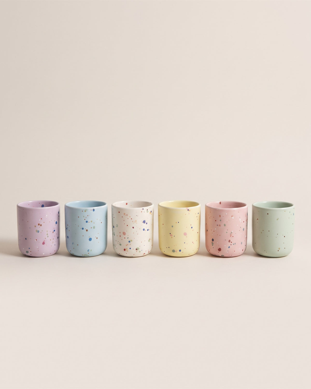Lot de six tasses expresso coquetiers New Party en céramique pastel, vue de face sur fond pierre