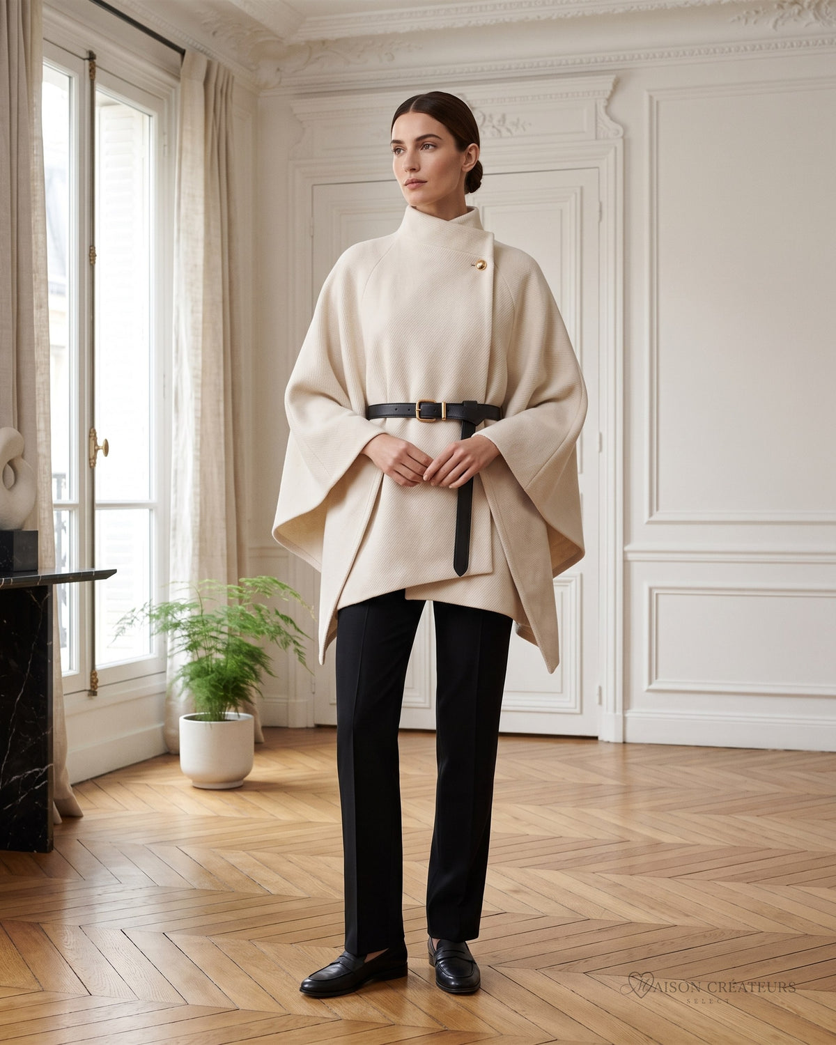Poncho écru à ceinture noire porté dans un salon haussmannien