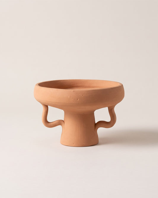 Coupe sur pied en céramique terracotta faite main, vue de face sur fond pierre
