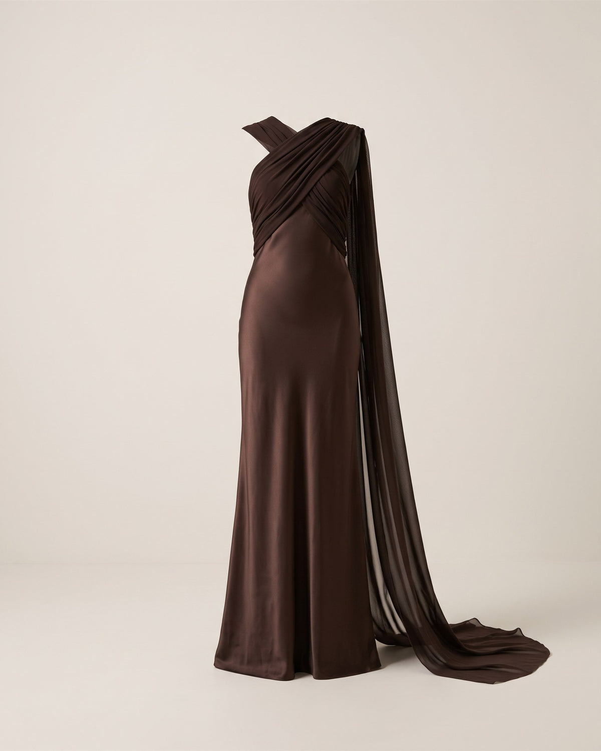 Robe longue Élégance chocolat avec cape fluide, vue de face sur fond pierre