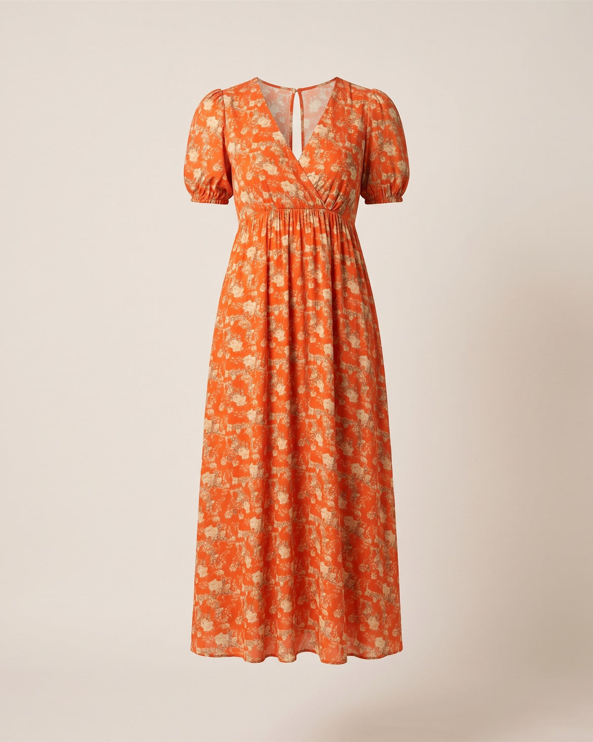 Robe Scarlett à imprimé floral orange et dos noué, vue de face sur fond pierre