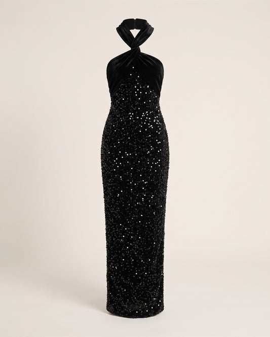 Robe longue noire en sequins et velours à épaule asymétrique, vue de face sur fond pierre