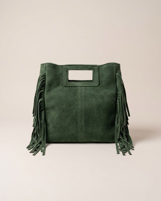 Le sac Marion en cuir daim vert, forme carrée à poignée découpée et franges sur les côtés, vue de face sur fond pierre