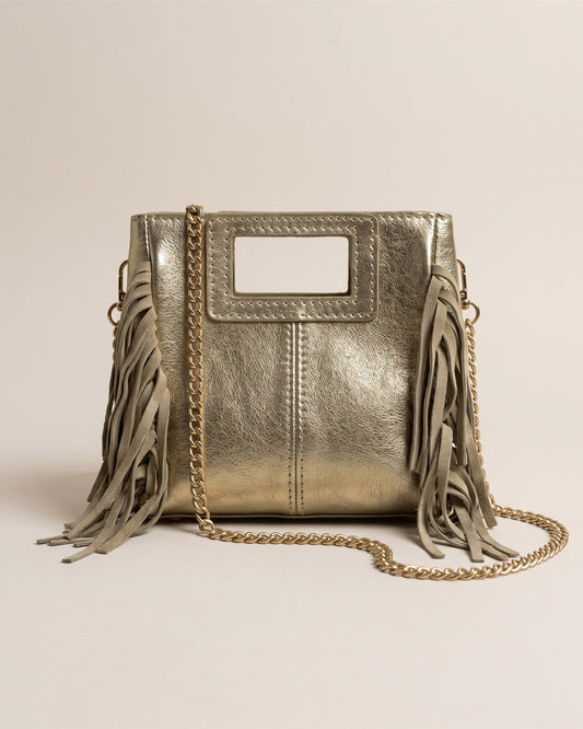 Le sac Marion Small en cuir irisé doré métallisé, forme carrée à poignée découpée, franges sur les côtés et chaîne dorée, vue de face sur fond pierre