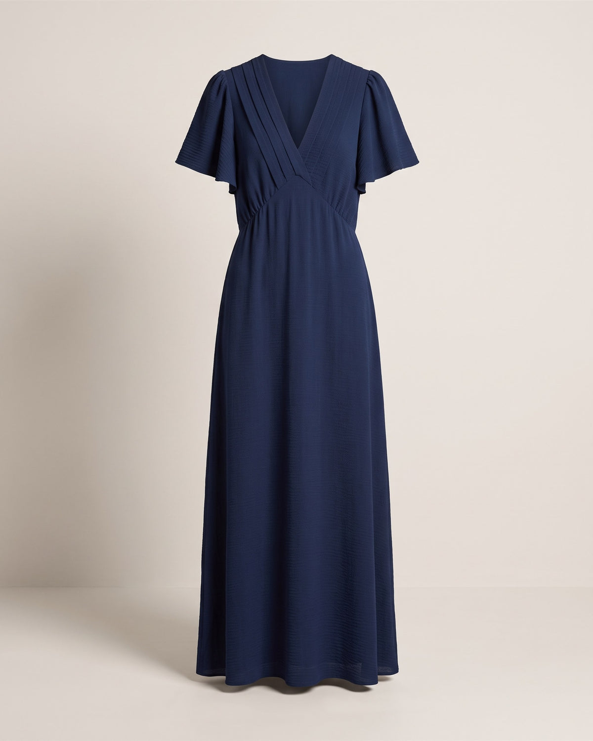 Robe longue Céleste bleu marine à col V et manches tulipe, vue de face sur fond pierre