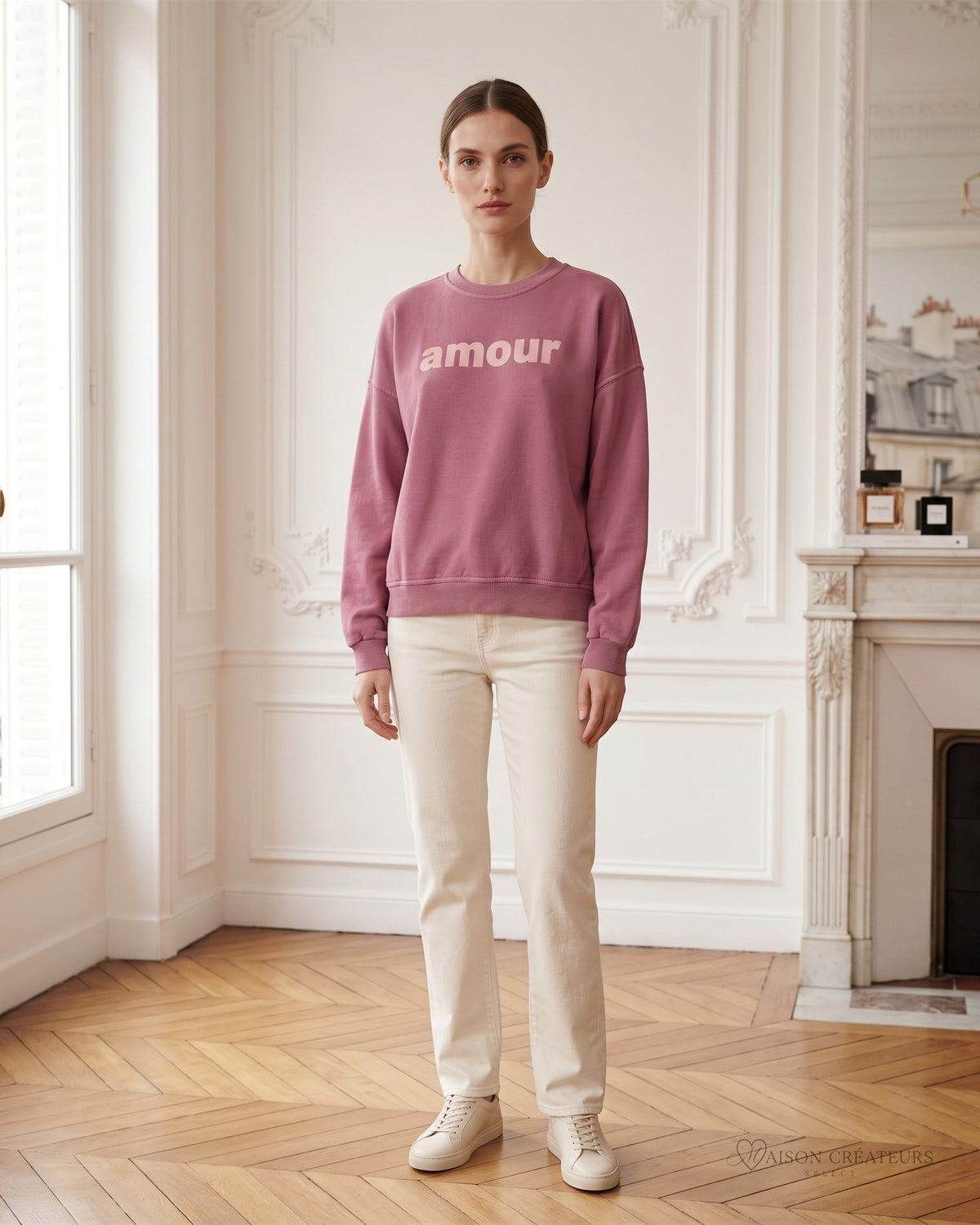 Sweat oversize rose Amour porté dans un salon haussmannien